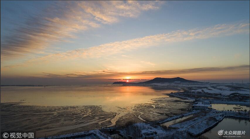 2018年12月10日,山东威海,荣成市天鹅湖畔现日初绚丽美景,过冬天鹅雪